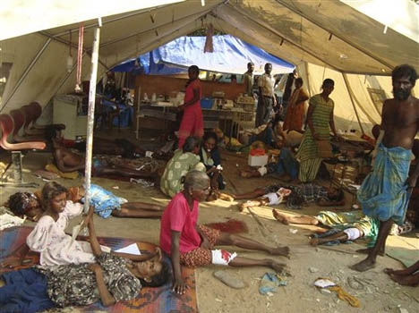 Injured Sri Lankan ethnic Tamil civilians trapped in Tiger controlled war zone wait for medical treatment in a makeshift hospital in Mullivaikal, Sri Lanka, Monday, May 4, 2009. (AP Photo)